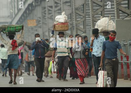 Immer top informiert gehen an der howrah-Brücke an einem nebligen Morgen über den Ganga-Fluss vorbei, inmitten eines Coronavirus-Notfalls am 21. Januar 2022 in Kalkata, Westbengalen, Indien. (Foto von Debajyoti Chakraborty/NurPhoto) Stockfoto