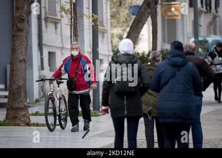 Am 23. Januar 2022 läuft ein Mann mit seinem Fahrrad an der Akropolis Heel mit einer geschützten Maske in Athen, Griechenland. (Foto von Nikolas Kokovlis/NurPhoto) Stockfoto
