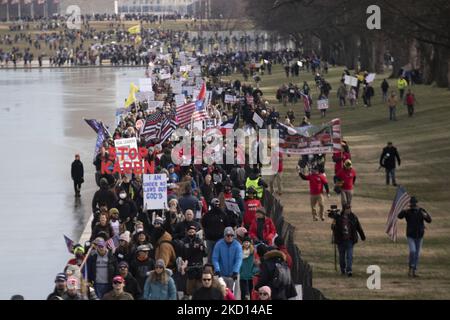 Am 23. Januar 2022 marschieren Menschen vom Washington Monument zum Lincoln Memorial für die „Defeat Mandates“-Kundgebung. Das eintägige Ereignis sprach sich gegen Maske- und Impfvorschriften aus, die in den Vereinigten Staaten vorgeschlagen und erlassen wurden, um die Ausbreitung von COVID-19 einzudämmen. (Foto von Zach Brien/NurPhoto) Stockfoto