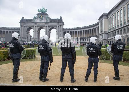 Polizisten im Jubelpark mit den Arcades du Cinquantenaire - Triumph Arch. Tausende protestieren während der europäischen Demonstration für Demokratie gegen Covid-bezogene Maßnahmen wie den COVID Health Pass and Restrictions. Die Unruhen begannen auszubrechen und die Polizei feuern Tränengas und Wasserwerfer, als der Protest gewalttätig wurde. Menschen nehmen an einer Demonstration gegen Gesundheitsmaßnahmen in Brüssel wie dem COVID Health Pass, dem QR-Code, Gesichtsmasken und der obligatorischen Impfung Teil, wobei das Wort liberte als Hauptmotto und auf Transparenten als Freiheit übersetzt wird. Die Behörden schätzten, dass rund 50.000 pepl Stockfoto