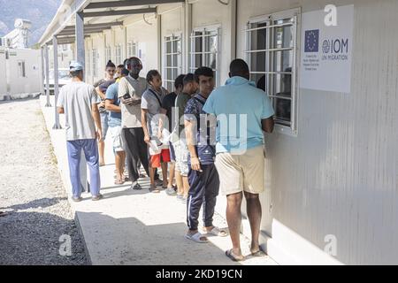 Die Leute warten in der Schlange, um die Verteilung der Mittagsgerichte zu erhalten. Innerhalb des neuen Flüchtlingslagers auf der Insel Samos, das mit Unterstützung der EU in Griechenland eingerichtet wurde, ist es die erste von der EU finanzierte geschlossene kontrollierte Einrichtung, das neue Samos RIC (Reception and Identification Center) Da Europa 276 Millionen Euro EU-Mittel für neue Camps auf den Inseln Samos, Lesbos, Chios, Kos und Leros ausgeben wird. Tägliches Leben im neuen Migrantenlager mit den Fertighäusern, einer geschlossenen kontrollierten Einrichtung, in die Menschen nur mit ihrer Karte zusätzlich zu ihrem biometrischen Fingerabdruck eintreten können. Das neue Lager Stockfoto