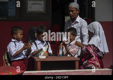 Die Schüler reinigen ihre Hände mit Desinfektionsmittel, bevor sie am 26. Januar 2022 in der öffentlichen Grundschule Porame, Dorf Porame, Sigi Regency, Provinz Zentral-Sulawesi, Indonesien gegen COVID-19 geimpft werden. Nach der Impfung von COVID-19 bis 182,86 Millionen der 208 Millionen Bevölkerung im Alter von 12 Jahren und über dem Ziel beginnt die indonesische Regierung nun mit der Impfung von Kindern im Alter von 6-12 Jahren mit einem Ziel von 26,5 Millionen Kindern. Die Impfung des Kindes soll den Lernprozess von Angesicht zu Angesicht sichern, der jetzt in Grundschulen umgesetzt wurde. (Foto von Basri Marzuki/NurPhoto) Stockfoto