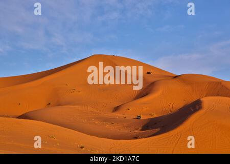 Geländewagen mit Touristen fahren entlang der Sanddünen in der Nähe des kleinen Dorfes Merzouga in Marokko, Afrika. Merzouga ist ein Dorf in der Sahara in Marokko, am Rande von Erg Chebbi, einem 50km langen und 5km breiten Sanddünen-Set, das bis zu 350m erreicht. (Foto von Creative Touch Imaging Ltd./NurPhoto) Stockfoto