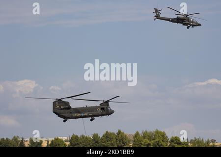 Ein Hubschrauber der griechischen Armee der Boeing AH-64 Apache mit einer Boeing CH-47 Chinook, der während einer Flugdemonstration während der Flugwoche 2021 auf dem Flughafen Tanagra geflogen und manövriert wurde. Der Apache des hellenischen Militärs ist die AH-64D Apache Longbow Version. Das spezifische Flugzeug ist ein zweifach-Turbowellen-Kampfhubschrauber unter dem Rumpf und auf den Flügeln mit einem Maschinengewehr, Raketen, Raketen- und Selbstverteidigungsfähigkeiten. Griechenland, ein Land mit starken Luftstreitkräften, ist Mitglied der NATO-Organisation für den Nordatlantikvertrag. Tanagra, Griechenland am September Stockfoto