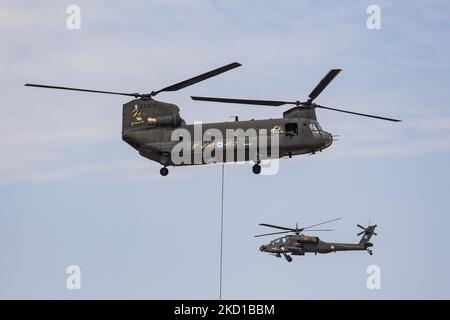 Ein Hubschrauber der griechischen Armee der Boeing AH-64 Apache mit einer Boeing CH-47 Chinook, der während einer Flugdemonstration während der Flugwoche 2021 auf dem Flughafen Tanagra geflogen und manövriert wurde. Der Apache des hellenischen Militärs ist die AH-64D Apache Longbow Version. Das spezifische Flugzeug ist ein zweifach-Turbowellen-Kampfhubschrauber unter dem Rumpf und auf den Flügeln mit einem Maschinengewehr, Raketen, Raketen- und Selbstverteidigungsfähigkeiten. Griechenland, ein Land mit starken Luftstreitkräften, ist Mitglied der NATO-Organisation für den Nordatlantikvertrag. Tanagra, Griechenland am September Stockfoto