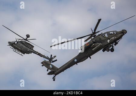 Ein Hubschrauber der Boeing AH-64 Apache und ein Hubschrauber der griechischen Armee Bell OH-58 Kiowa während einer Flugdemonstration während der Flugwoche 2021 in Athen auf dem Flughafen der Tanagra Air Base. Der Apache des hellenischen Militärs ist die AH-64D Apache Longbow Version. Das spezifische Flugzeug ist ein zweifach-Turbowellen-Kampfhubschrauber unter dem Rumpf und auf den Flügeln mit einem Maschinengewehr, Raketen, Raketen- und Selbstverteidigungsfähigkeiten. Griechenland, ein Land mit starken Luftstreitkräften, ist Mitglied der NATO-Organisation für den Nordatlantikvertrag. Tanagra, Griechenland o Stockfoto