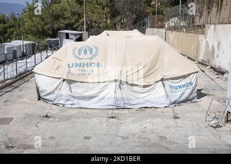 Weiße Zelte im offiziellen Lager mit dem Logo des UNHCR - DES UN-Flüchtlingshilfswerks. Das ehemalige offizielle Flüchtlingslager, das von Stacheldrahtzaun auf der Insel Vathy auf Samos umgeben ist, und das benachbarte provisorische Lager mit handgefertigten Zelten und einigen von UNHCR, das sich direkt neben den Häusern der Stadt Vathi befindet, wie es als verlassen gilt. Das Lager wurde geleert und die Leute wurden umgesiedelt oder mit der Polizeieskorte in das neue Lager und einige wenige Häuser verlegt. Einst beherbergte diese Einrichtung zu ihren Höchstzeiten 7500 Asylbewerber in den offiziellen Einrichtungen, aber auch das provisorische Lager im Wald, das den Spitznamen Jun erhielt Stockfoto