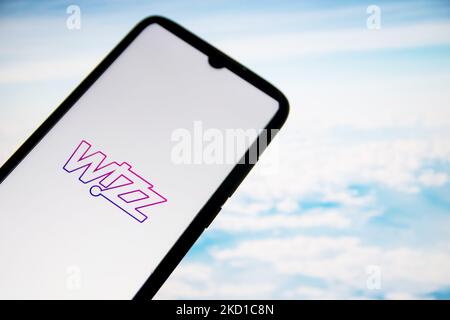 In dieser Abbildung ist ein Logo der Wizz Air Airlines zu sehen, das am 27. Januar 2022 in Athen, Griechenland, auf einem Smartphone-Bildschirm mit einem Computertapeten im Hintergrund angezeigt wird. (Fotoillustration von Nikolas Kokovlis/NurPhoto) Stockfoto