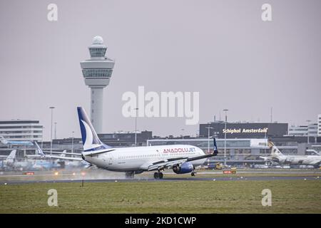 Anadolu Jet Boeing 737-800-Flugzeuge, wie sie bei endgültiger Annäherung am Flughafen Amsterdam Schiphol landen AMS EHAM, wenn das Flugzeug bei bewölktem Wetter aus der Türkei ankommt und auf der Start- und Landebahn vor dem Flughafenterminal, anderen KLM-Flugzeugen und dem Kontrollturm landet. Der B738 hat die Registrierung TC-JZJ. AnadoluJet ist eine regionale Fluggesellschaft, eine Marke von Turkish Airlines, Mitglied des Luftfahrtkonzerns Star Alliance, die von den Flughäfen Istanbul-Sabiha Gökçen und Ankara aus operiert. Die Luftfahrtindustrie und der Personenverkehr befinden sich in einer schwierigen Phase, in der die Coronavirus-Pandemie Covid-19 negativ ausbricht Stockfoto