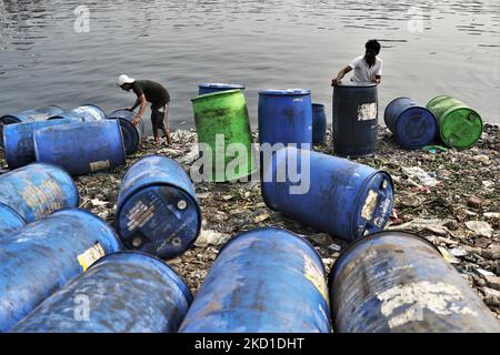 Am 28. Januar 2022 reinigen die Arbeiter Kunststofffässer im Fluss Buriganga zur weiteren Chemielieferung in Dhaka, Bangladesch. Der Buriganga River, der durch die Stadt Dhaka fließt, ist heute einer der am stärksten verschmutzten Flüsse in Bangladesch, weil dort immer mehr Industrie- und Menschenabfälle dedumpiert werden. (Foto von Syed Mahamudur Rahman/NurPhoto) Stockfoto