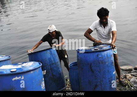 Am 28. Januar 2022 reinigen die Arbeiter Kunststofffässer im Fluss Buriganga zur weiteren Chemielieferung in Dhaka, Bangladesch. Der Buriganga River, der durch die Stadt Dhaka fließt, ist heute einer der am stärksten verschmutzten Flüsse in Bangladesch, weil dort immer mehr Industrie- und Menschenabfälle dedumpiert werden. (Foto von Syed Mahamudur Rahman/NurPhoto) Stockfoto