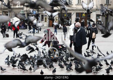 Eine Frau füttert am 29. Januar 2022 in Krakau, Polen, Tauben. (Foto von Jakub Porzycki/NurPhoto) Stockfoto