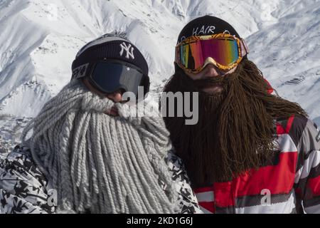 Zwei iranische Snowboarder, die gefälschte Bärte tragen, posieren für ein Foto, während sie am 28. Januar 2022 auf einer Piste im Darbandasar-Skigebiet 67km (42 Meilen) nordöstlich von Teheran stehen. Trotz der Prävalenz der Omicron-Variante der neuen Coronavirus-Krankheit (COVID-19) im Iran, Die Stadt Teheran befindet sich noch immer nicht in einer roten (hochriskant) Situation und die Menschen können immer noch Spaß haben und Skifahren auf den Skipisten. Aber nach dem neuesten Bericht der Iran Metropolitan News Agency (IMNA), in der neuen Situation der Prävalenz der Omicron-Variation von Covid-19 im Iran, Provinz Qom, die der Nachbar von teh ist Stockfoto