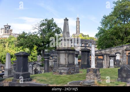 Friedhof von Old Calton im Stadtzentrum von Edinburgh und Nelson Tower Schottland, Großbritannien, Sommer 2022 mit Calton Hill in der Ferne Stockfoto