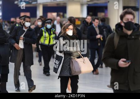 LONDON, GROSSBRITANNIEN - 02. FEBRUAR 2022: Pendler, einige davon tragen weiterhin Gesichtsmasken, kommen am 02. Februar 2022 während der morgendlichen Hauptverkehrszeit in London, England, am Bahnhof Waterloo an. Seit der Lockerung der Covid-19-Maßnahmen in der vergangenen Woche, als Arbeitnehmer und Käufer in die Innenstadt zurückkehren, ist die Zahl der Fahrgäste im gesamten Verkehrsnetz gestiegen. Gestern verzeichnete das Vereinigte Königreich 112.458 neue Fälle, da Reinfektionen erstmals in die offiziellen Statistiken aufgenommen wurden. (Foto von Wiktor Szymanowicz/NurPhoto) Stockfoto