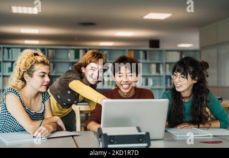Junge Studenten mit Laptop und Studium mit Büchern in der Bibliothek - Schulbildung Konzept Stockfoto