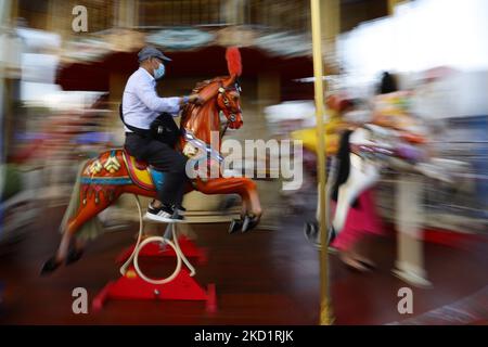 Ein Mann mit Schutzmaske reitet während des River Hongbao Festivals, das im Rahmen der chinesischen Neujahrsfeier in Gardens by the Bay am 3. Februar 2022 in Singapur stattfand, ein Karussell. (Foto von Suhaimi Abdullah/NurPhoto) Stockfoto