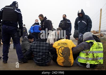 Polizisten behalten die Aktivisten im Auge, nachdem sie aus den Toren der Baustelle vertrieben wurden. Mehrere Dutzend Aktivisten von XR, ANV-COP21, ATTAC, Youth for Climate versammelten sich in Saint Sulpice La Pointe, um die Baustelle des riesigen Lagerhauses von Terra2 zu blockieren. Sie lehnen ein riesiges Lager ab, das für Amazon oder Alibaba geplant ist und mehrere landwirtschaftliche Felder abdeckt. Die Haupthalle sollte 533 m lang, 125m breit und 17m hoch sein und würde in den Top 10 der größten Lagerhäuser in Frankreich sein. Die Bauarbeiten hätten in diesem Winter nicht beginnen sollen, da Stop Terra2 eine Aske hat Stockfoto