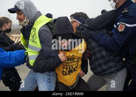 Polizisten lösen Aktivisten vom Eingang der Baustelle ab. Mehrere Dutzend Aktivisten von XR, ANV-COP21, ATTAC, Youth for Climate versammelten sich in Saint Sulpice La Pointe, um die Baustelle des riesigen Lagerhauses von Terra2 zu blockieren. Sie lehnen ein riesiges Lager ab, das für Amazon oder Alibaba geplant ist und mehrere landwirtschaftliche Felder abdeckt. Die Haupthalle sollte 533 m lang, 125m breit und 17m hoch sein und würde in den Top 10 der größten Lagerhäuser in Frankreich sein. Die Bauarbeiten hätten in diesem Winter nicht beginnen sollen, da Stop Terra2 die Justiz gebeten hat, die Legali zu beurteilen Stockfoto