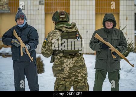 Der Soldatentrainer der Territorial Defense Brigade 112. in Kiew erklärt, wie man ein Gewehr bei einer Militärübung in den Außenbezirken der Stadt einigen zivilen Freiwilligen hält. Das Verteidigungsministerium schuf in den Hauptstädten Verteidigungsbrigaden, weil die hohe Spannung mit dem Aufbau russischer Truppen an seiner Grenze und die Gefahr einer Invasion durch Russland besteht. (Foto von Celestino Arce/NurPhoto) Stockfoto