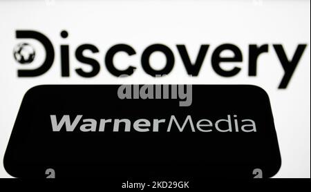 Das WarnerMedia-Logo auf einem Telefonbildschirm und das Discovery-Logo auf einem Laptop-Bildschirm sind auf diesem Illustrationsfoto zu sehen, das am 9. Februar 2022 in Krakau, Polen, aufgenommen wurde. (Foto-Illustration von Jakub Porzycki/NurPhoto) Stockfoto