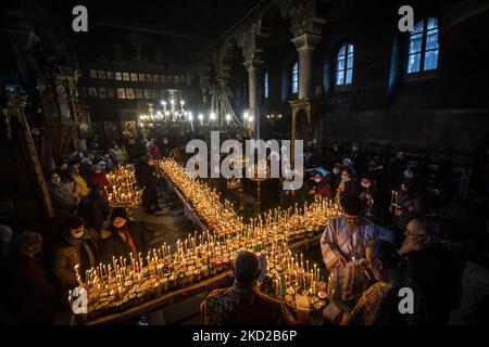 Gläubige zünden Kerzen auf Honigkrügen an, während sie am 10. Februar 2022 in der Kirche zur Darstellung der seligen Jungfrau in Blagoevgrad, Westbulgarien, ein religiöses Ritual anlässlich des Tages des heiligen Haralampi, des orthodoxen schutzpatrons der Imker, durchführen. (Foto von Georgi Paleykov/NurPhoto) Stockfoto