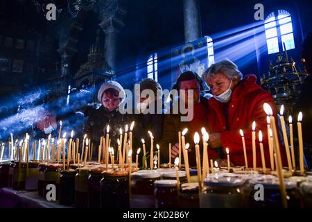 Gläubige zünden Kerzen auf Honigkrügen an, während sie am 10. Februar 2022 in der Kirche zur Darstellung der seligen Jungfrau in Blagoevgrad, Westbulgarien, ein religiöses Ritual anlässlich des Tages des heiligen Haralampi, des orthodoxen schutzpatrons der Imker, durchführen. (Foto von Georgi Paleykov/NurPhoto) Stockfoto