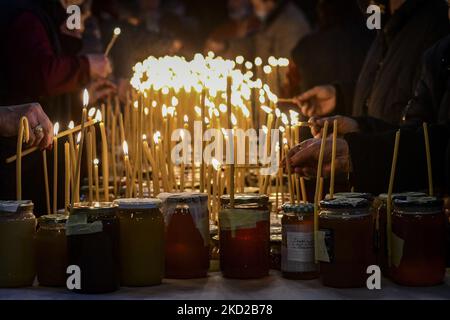 Gläubige zünden Kerzen auf Honigkrügen an, während sie am 10. Februar 2022 in der Kirche zur Darstellung der seligen Jungfrau in Blagoevgrad, Westbulgarien, ein religiöses Ritual anlässlich des Tages des heiligen Haralampi, des orthodoxen schutzpatrons der Imker, durchführen. (Foto von Georgi Paleykov/NurPhoto) Stockfoto