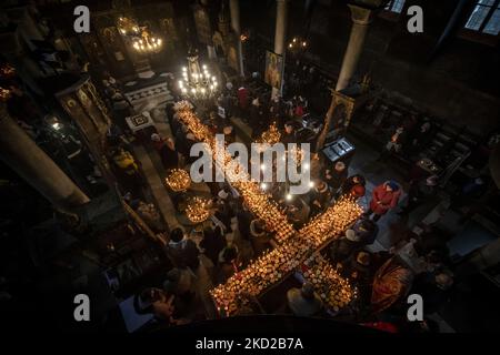 Gläubige zünden Kerzen auf Honigkrügen an, während sie am 10. Februar 2022 in der Kirche zur Darstellung der seligen Jungfrau in Blagoevgrad, Westbulgarien, ein religiöses Ritual anlässlich des Tages des heiligen Haralampi, des orthodoxen schutzpatrons der Imker, durchführen. (Foto von Georgi Paleykov/NurPhoto) Stockfoto