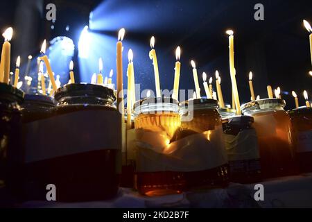 Gläubige zünden Kerzen auf Honigkrügen an, während sie am 10. Februar 2022 in der Kirche zur Darstellung der seligen Jungfrau in Blagoevgrad, Westbulgarien, ein religiöses Ritual anlässlich des Tages des heiligen Haralampi, des orthodoxen schutzpatrons der Imker, durchführen. (Foto von Georgi Paleykov/NurPhoto) Stockfoto