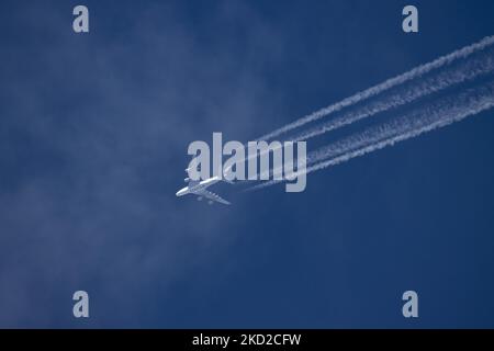 Qatar Airways Airbus A380-Doppeldecker überfliegt an einem sonnigen Tag über Europa 40,000 Meter am blauen Himmel und verbindet die Hauptstadt des Flughafens Katar Doha mit London Heathrow LHR in Großbritannien. A388 das überfliegende Großkörper-Düsenflugzeug hat den Aufdruck MIT DEM QATAR-Logo auf der Unterseite des Rumpfes und hinterlässt Kondensstreifen, eine weiße Dampflinie. Die A380 ist ein großes Großkörperflugzeug, das größte Passagierflugzeug der Welt. Das spezifische Quadjet-Doppeldeck hat die Registrierung A7-APH und wird von 4x EA Engine Alliance GP7200 Jet-Motor angetrieben Stockfoto