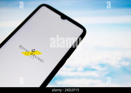 Auf dieser Fotolabbildung ist ein Logo der Royal Brunei Airlines zu sehen, das am 12. Februar 2022 in Athen, Griechenland, auf einem Smartphone-Bildschirm mit einem Computertapete im Hintergrund angezeigt wird. (Foto-Illustration von Nikolas Kokovlis/NurPhoto) Stockfoto