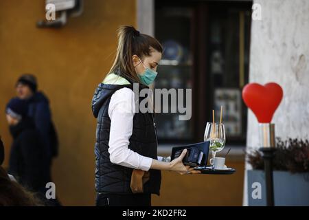 Am 12. Februar 2022 wird in der Altstadt von Warschau, Polen, ein Kellner mit Gesichtsmaske gesehen. Gesundheitsminister Adam Niedzielski kündigte diese Woche das Ende der COVID-19-Pandemie in Polen an. Niedzielski kündigte zudem die Aufhebung der Beschränkungen im März an, vorausgesetzt, die Zahl der neuen Fälle sinkt weiterhin mit der aktuellen Rate. Die Nachrichten des Gesundheitsministeriums trotzen den aktuellen Statistiken, die zeigen, dass Polen eine der höchsten Todesraten in Europa und eine Stagnation der Impfraten hat. (Foto von STR/NurPhoto) Stockfoto