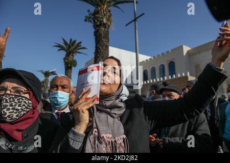 Eine Unterstützerin der islamistisch inspirierten Partei Ennahda küsst eine Kopie der tunesischen Verfassung während einer Demonstration auf Initiative der Kampagne „Bürger gegen den Putsch – die Demokratische Initiative“ am 13. Februar 2022 in der Mohamed 5 Avenue in der Hauptstadt Tunis, Tunesien, Um gegen die Auflösung des Obersten Justizrats des Landes zu protestieren und die Unabhängigkeit der Justiz zu fordern. Die Demonstranten forderten auch die Freilassung des Vizepräsidenten der Ennahda-Partei Noureddine Bhiri, der seit mehr als sechs Wochen unter Hausarrest gestellt wird. Demonstranten protestierten auch gegen Agai Stockfoto