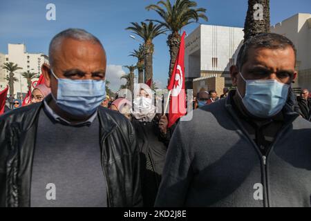 Eine Unterstützerin der islamistisch inspirierten Partei Ennahda mit tunesischer Flagge nimmt an einer Demonstration Teil, die auf Initiative der Kampagne „Bürger gegen den Putsch – die Demokratische Initiative“ am 13. Februar 2022 auf der Mohamed 5 Avenue in der tunesischen Hauptstadt Tunis stattfand, um die Unabhängigkeit der Justiz zu fordern. Die Demonstranten forderten auch die Freilassung des Vizepräsidenten der Ennahda-Partei Noureddine Bhiri, der seit mehr als sechs Wochen unter Hausarrest gestellt wird. Die Demonstranten protestierten auch gegen einen Putsch, der sie auf die Machtergreifung des Präsidenten Kais Saied und die e hinwies Stockfoto