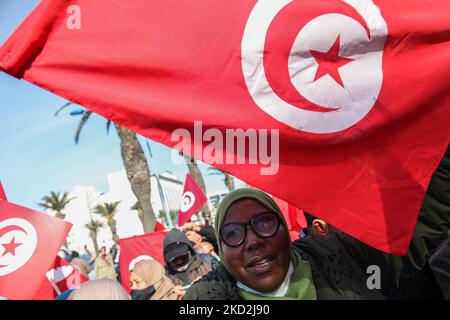 Eine Unterstützerin der islamistisch inspirierten Partei Ennahda hebt die tunesische Flagge während einer Demonstration auf Initiative der Kampagne „Bürger gegen den Putsch – die Demokratische Initiative“ am 13. Februar 2022 in der Mohamed 5 Avenue in der tunesischen Hauptstadt Tunis, Um gegen die Auflösung des Obersten Justizrats des Landes zu protestieren und die Unabhängigkeit der Justiz zu fordern. Die Demonstranten forderten auch die Freilassung des Vizepräsidenten der Ennahda-Partei Noureddine Bhiri, der seit mehr als sechs Wochen unter Hausarrest gestellt wird. Demonstranten protestierten auch gegen das, was sie Stockfoto