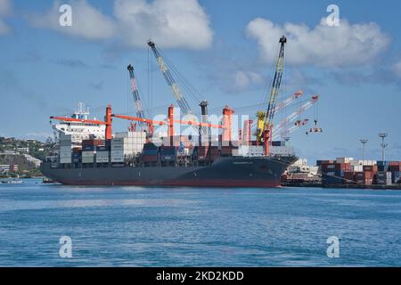 Eine schöne Aufnahme eines Containerschiffes und Kraniche im Tahiti Hafen von Papeete in Frankreich Stockfoto