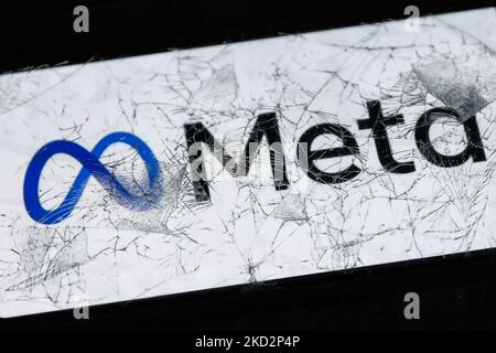 Das Meta-Logo, das auf einem Telefonbildschirm angezeigt wird, ist durch ein zerbrochenes Glas zu sehen. Dieses Bild wurde am 14. Februar 2022 in Krakau, Polen, aufgenommen. (Foto von Jakub Porzycki/NurPhoto) Stockfoto