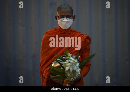 Thailändische buddhistische Mönche, die Schutzmasken tragen, warten darauf, während der Almosenzeremonie, die den Makha Bucha Day in Bangkok, Thailand, am 16. Februar 2022, feiert, Opfergaben von Anhängern zu erhalten. (Foto von Anusak Laowias/NurPhoto) Stockfoto