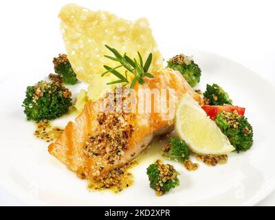 Gegrilltes Lachssteak mit Broccoli, Kartoffelpüree, Käsekracker isoliert auf weißem Hintergrund Stockfoto