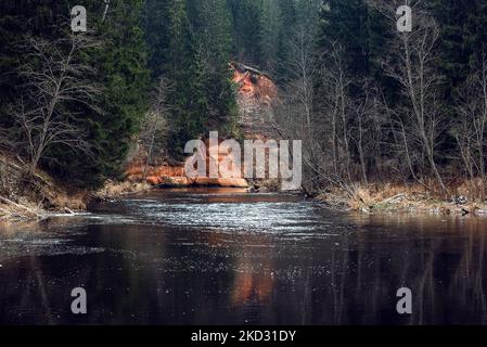Rote Sandklippen am Fluss Brasla, Lettland im Winter Stockfoto