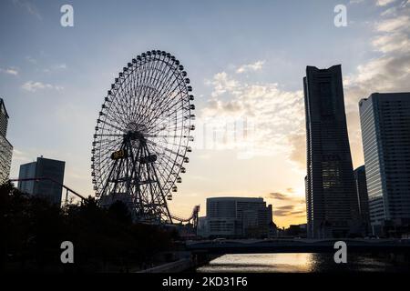 Yokohama, Kanagawa, Japan. 5.. November 2022. Die Sonne untergeht über dem Minatomirai 21 (Minato Mirai 21) Bezirk mit dem Cosmic Clock 21 Riesenrad und dem Yokohama Landmark Tower Bürogebäude und Observatorium. Yokohama ist eine wichtige Hafenstadt Japans mit einer reichen maritimen Geschichte und ist ein Zentrum der japanischen Industriewirtschaft. (Bild: © Taidgh Barron/ZUMA Press Wire) Bild: ZUMA Press, Inc./Alamy Live News Stockfoto