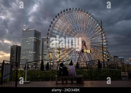 Yokohama, Kanagawa, Japan. 5.. November 2022. Die Sonne untergeht über dem Minatomirai 21 (Minato Mirai 21) Bezirk mit dem Cosmic Clock 21 Riesenrad. Yokohama ist eine wichtige Hafenstadt Japans mit einer reichen maritimen Geschichte und ist ein Zentrum der japanischen Industriewirtschaft. (Bild: © Taidgh Barron/ZUMA Press Wire) Bild: ZUMA Press, Inc./Alamy Live News Stockfoto