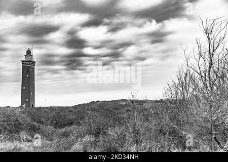 Schwarz-Weiß-Bild eines Leuchtturms in den Niederlanden. Der West Head Lighthouse - Vuurtoren Westhoofd ist ein niederländisches Nationaldenkmal, das für die Öffentlichkeit zugänglich ist. Der Westhoofd ein 52m hoher roter Leuchtturm mit einem quadratischen Turm, der den Seeweg der Nordseeküste beleuchtet, der nach dem Zweiten Weltkrieg in der Nähe von Ouddorp in der niederländischen Provinz Südholland in den Dünen am Groenedijk errichtet wurde. Ouddorp, Niederlande am 18. Februar 2022 (Foto von Nicolas Economou/NurPhoto) Stockfoto