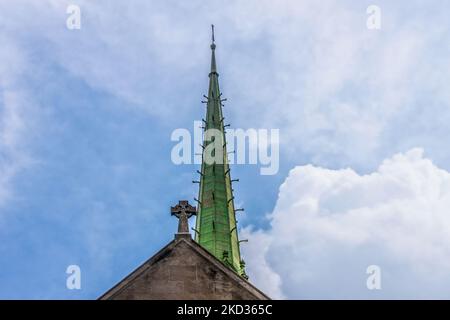 Kupfer Art Deco Kirchturm und keltisches Kreuz auf der Kirche gegen schönen wolkigen blauen Himmel Stockfoto