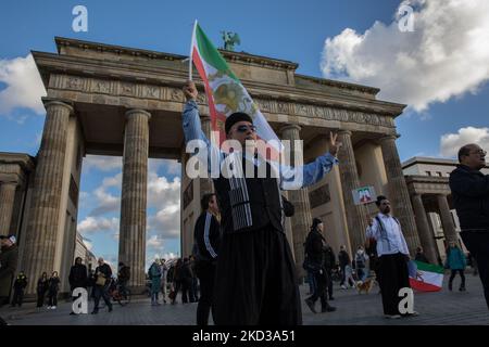 Berlin, Deutschland. 05.. November 2022. Ein Mann hält am 5. November 2022 am Brandenburger Tor in Berlin eine iranische Flagge hoch, er zeigt auch das V-Zeichen. (Foto: Michael Kuenne/PRESSCOV/Sipa USA) Quelle: SIPA USA/Alamy Live News Stockfoto