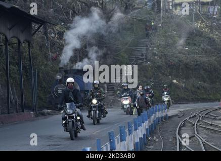 Biker fahren an einer Dampflok in der Nähe des Bahnhofs Darjeeling, Darjeeling, West Bengal, Indien, 23. Februar, 2022. Die Darjeeling Himalayan Railway, die gemeinhin als DHR oder der Toy Train bekannt ist, 2 Fuß Spurweite Eisenbahnlinie, die zwischen New Jalpaiguri und Darjeeling im indischen Bundesstaat West Bengal verläuft. Am 1999 erklärte die UNESCO die DHR zum Weltkulturerbe. (Foto von Indranil Aditya/NurPhoto) Stockfoto