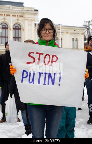 Eine Frau trägt ein Schild mit der Aufschrift „Stoppt Putin!“ Während einer Demonstration, bei der in Finnland lebende finnische und ukrainische Menschen gegen die russische Invasion in der Ukraine und in Solidarität mit dem ukrainischen Volk im Zentrum von Tampere, Finnland, am Donnerstag, dem 24.. Februar 2022, protestieren. (Foto von Tiago Mazza Chiaravalloti/NurPhoto) Stockfoto