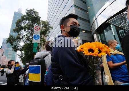 Demonstranten mit Nationalflaggen der Ukraine, einer mit Sonnenblumen, nehmen an einem Protest gegen russische Live-Feuer-Angriffe auf die Ukraine vor der Koordinierungskommission Moskau-Taipei in Taiwan in Taipei, Taiwan, am 25. Februar 2022 Teil. Mehrere westliche Länder, darunter die USA und das Vereinigte Königreich, haben Sanktionen gegen Russland verhängt, wobei baltische Staaten, darunter Litauen und Estland, die Ukraine unterstützen. (Foto von Ceng Shou Yi/NurPhoto) Stockfoto