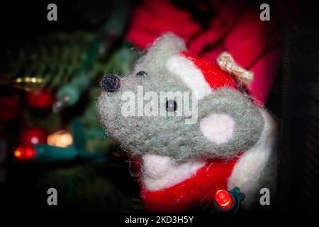 Verfilzte Weihnachtsmaus Nahaufnahme auf Baum mit künstlichen Lichtern in verschwommenem Hintergrund Stockfoto